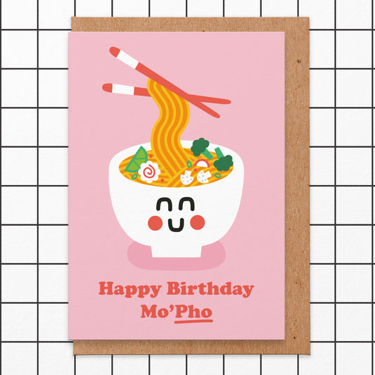 Greetings card with a pink background and an illustration of a bowl of pho and it reads happy birthday mo'pho!