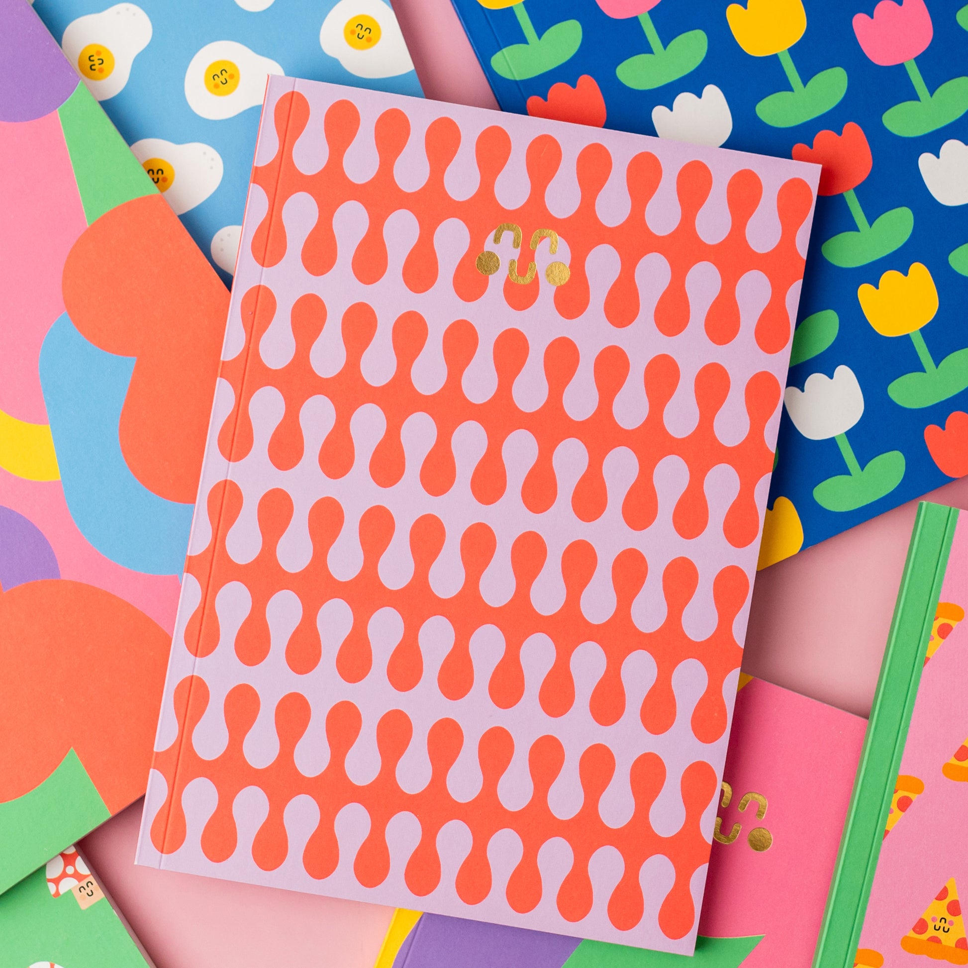 A collection of colorful notebooks with gold foil in a variety of patterns