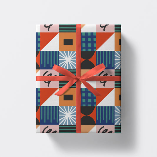 a square present wrapped in colourful geometric wrapping paper by studio boketto
