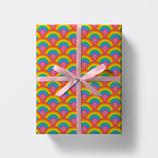 a square present wrapped in rainbow pattern wrapping paper by studio boketto