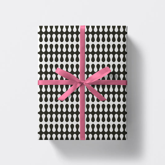 a square present wrapped in trippy pattern wrapping paper by studio boketto