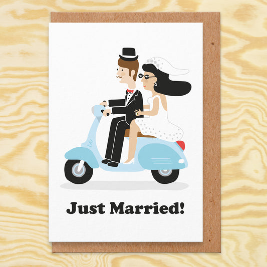 Wedding card that reads just married. There's an illustration of a retro scooter and a bride and groom riding it.