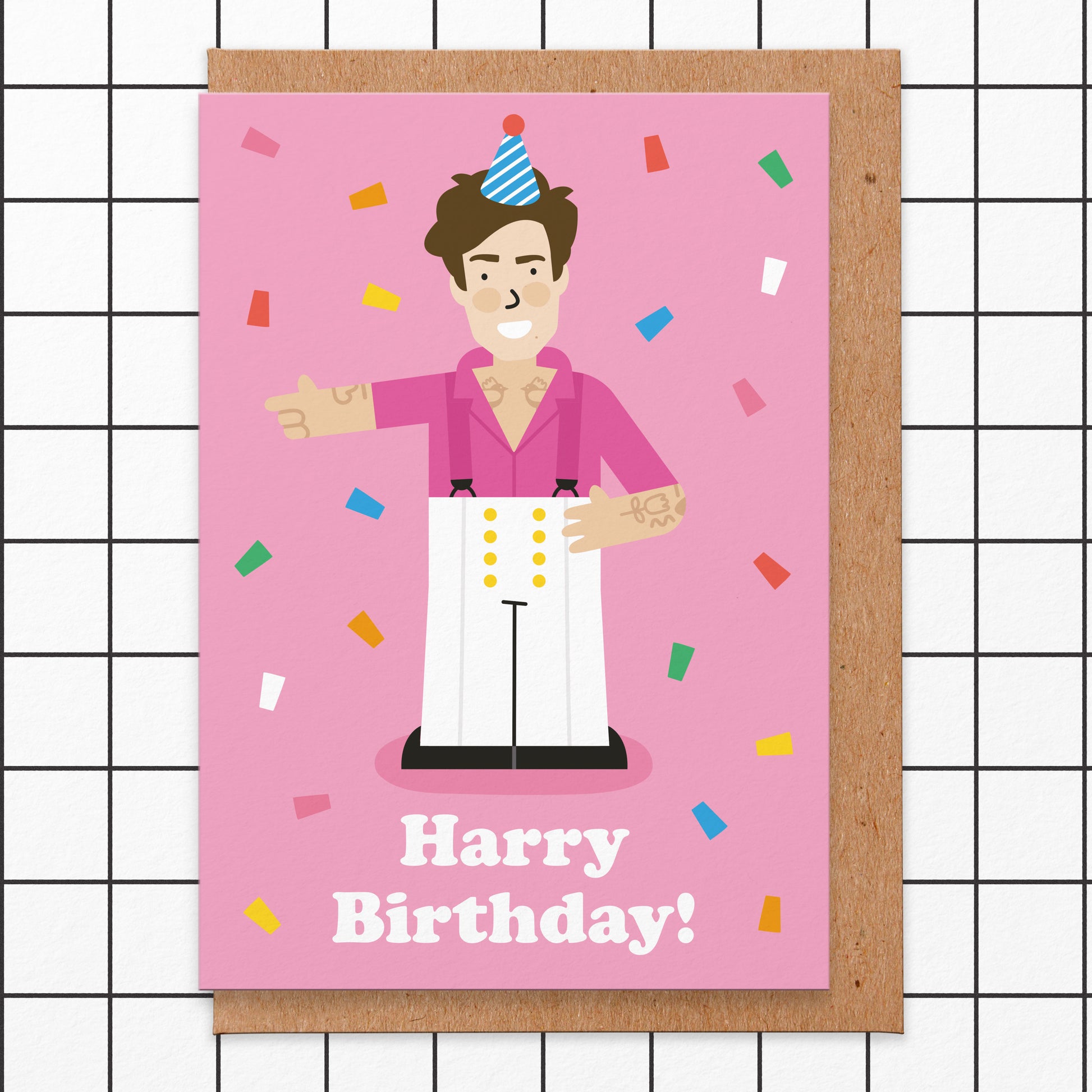 Pink birthday card that reads harry birthday and has an illustration of the pop singer wearing a party hat on.