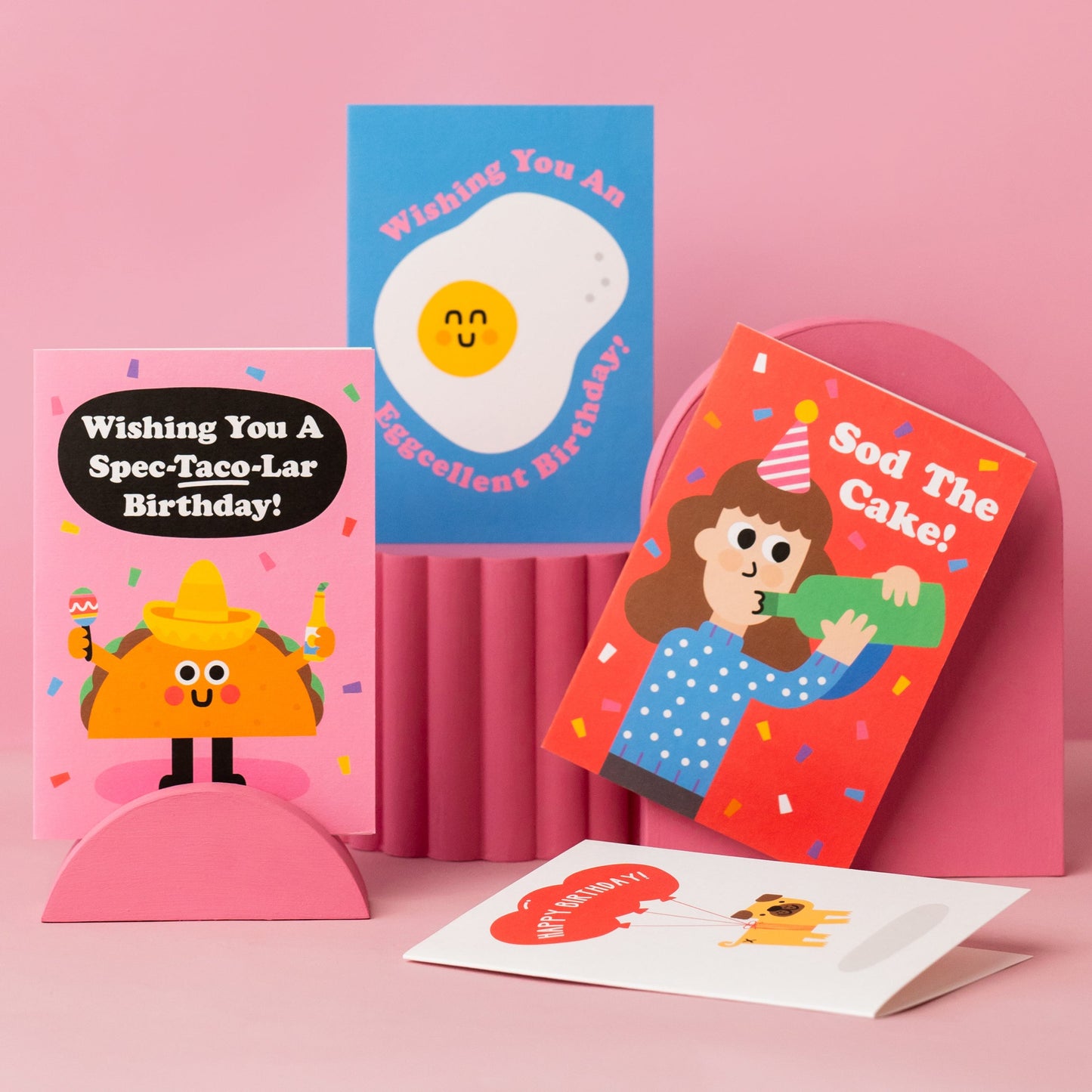 A collection of birthday cards on a pink background.