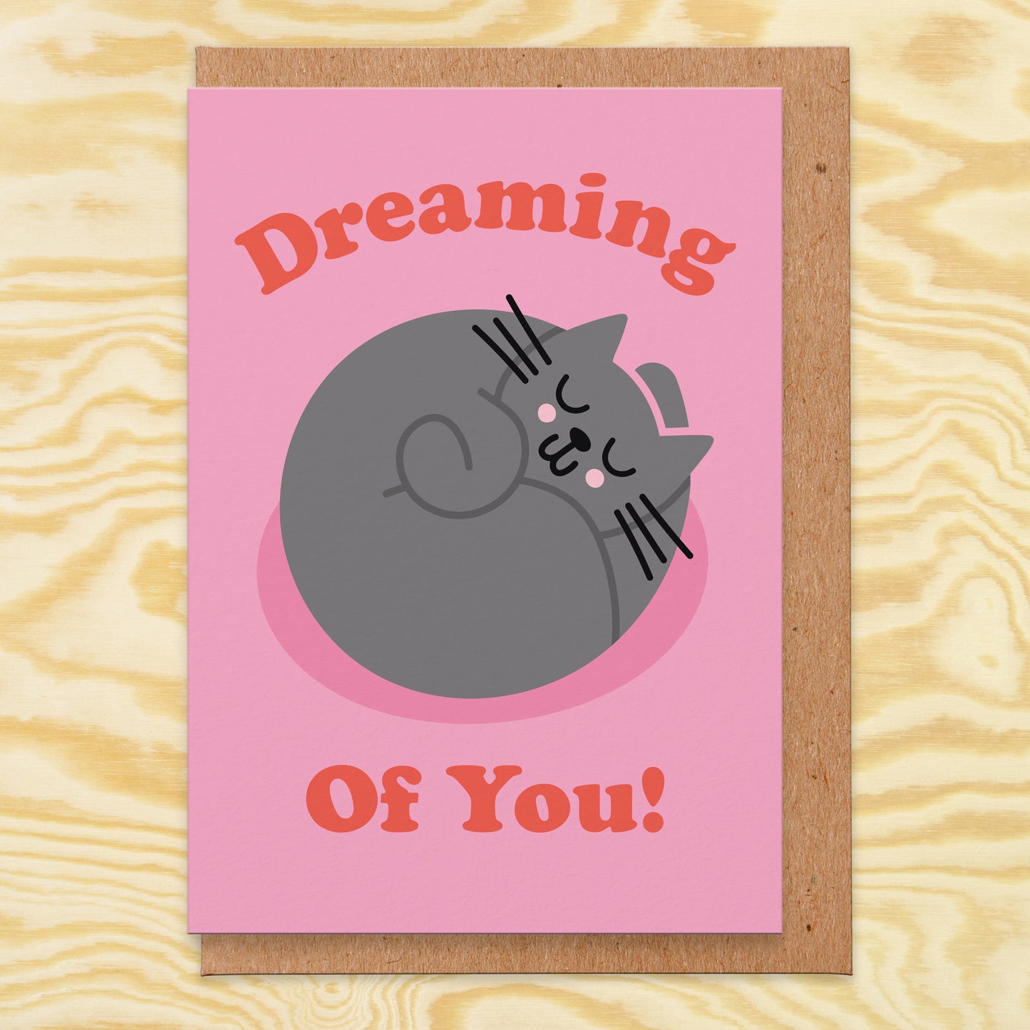 Love card with an illustration of a sleeping grey cat curled up in a ball and the text reads dreaming of you!