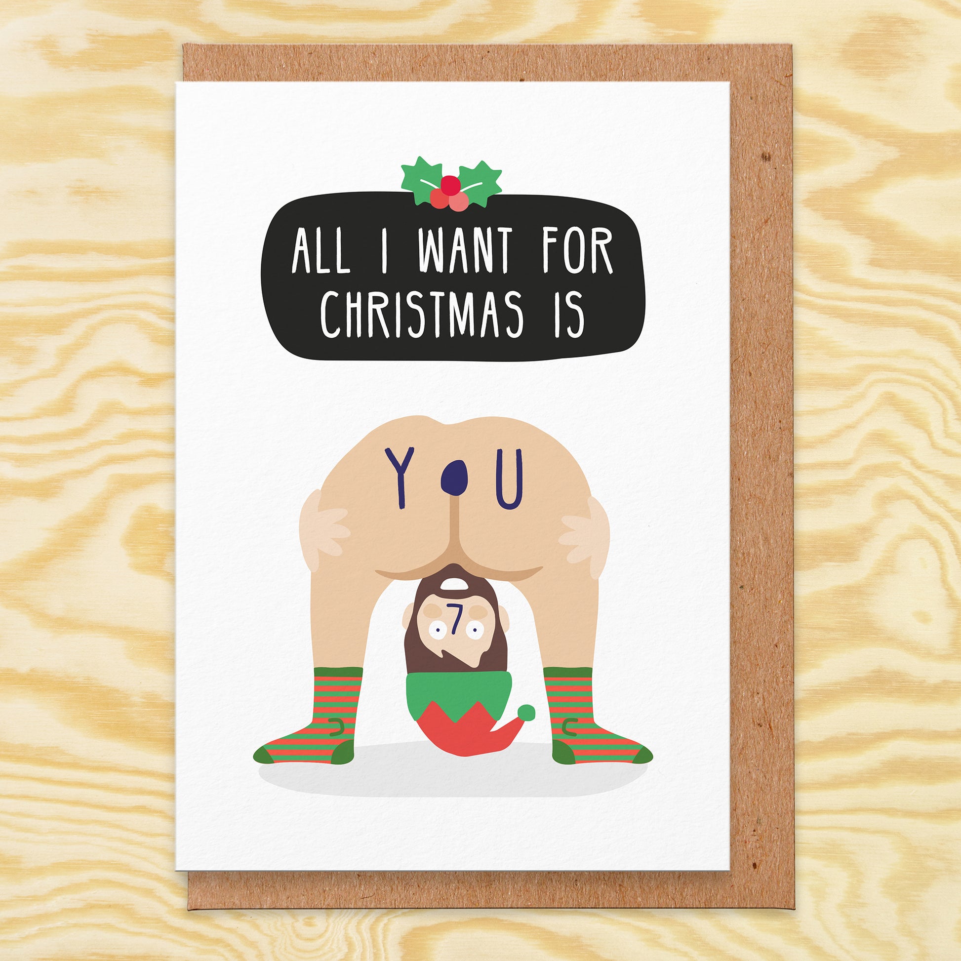 Christmas Greetings card that has an illustration of a man with an elf hat bending over  and showing his bum and it says All I Want For Christmas is You and the You is in the bum